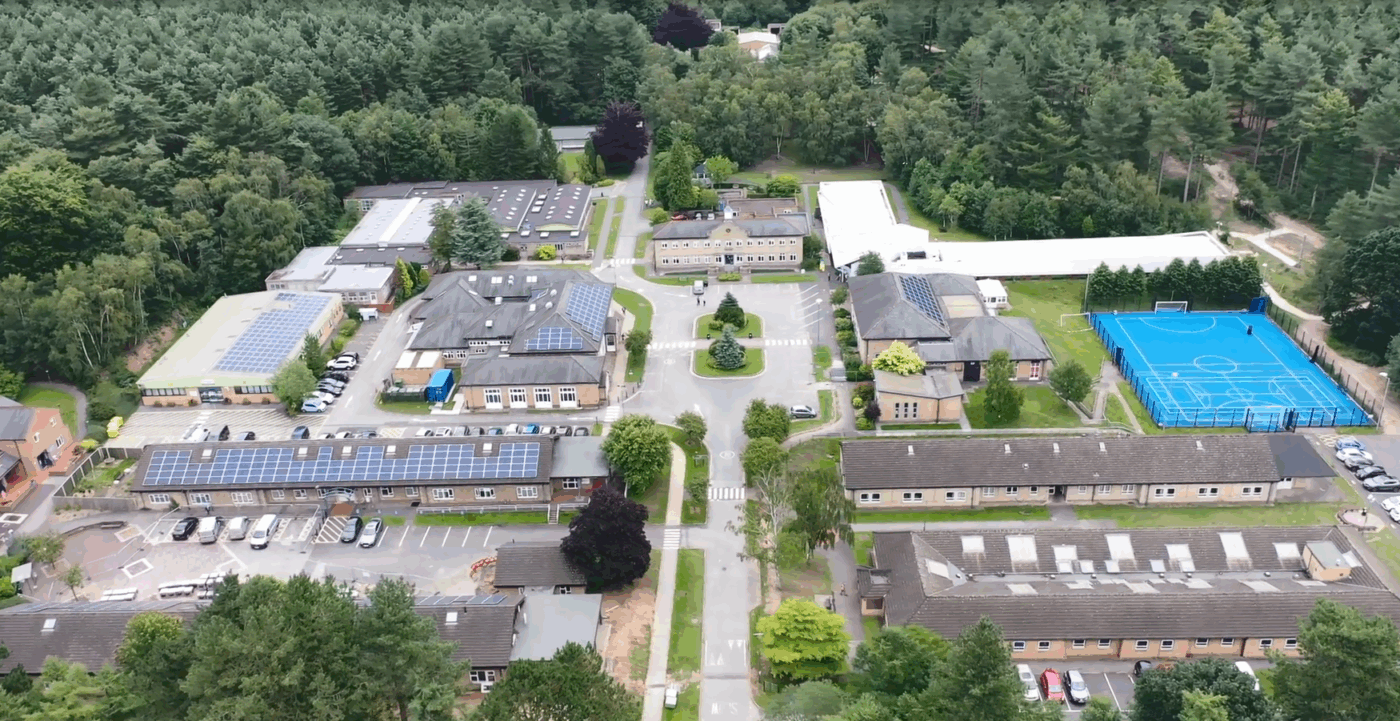 Birds eye view of the Portland College including a car parks on the left, buildings in the middle and tennis court on the right