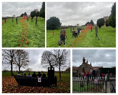 big pathces of green grass with leaves on the floor and red poppy plants in a trail leading to a brick house.